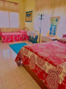 ein Schlafzimmer mit roten und weißen Decken und einem Bett in der Unterkunft Ramizu Homestay Pokok Sena in Pokok Sena