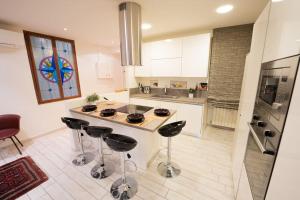 eine Küche mit einer Theke und Stühlen in der Unterkunft La Rosa Dei Venti Comfort Home in Triest