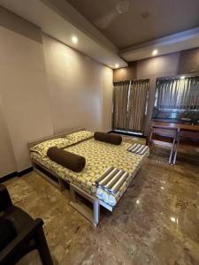 a bedroom with a bed in the corner of a room at GK Homestays - Luxurious Furnished Apartment in Salem