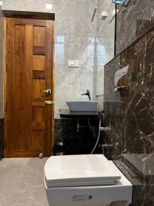 a bathroom with a white toilet and a sink at GK Homestays - Luxurious Furnished Apartment in Salem
