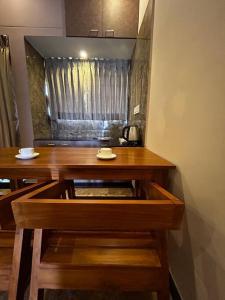 a wooden table with a mirror in a room at GK Homestays - Luxurious Furnished Apartment in Salem