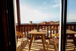 a table with a bottle of wine on a balcony at Annousa's House & Studios in Kallirakhi