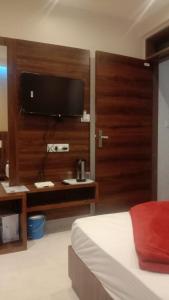 a bedroom with a bed and a flat screen tv at Hotel Starlight in Mount Ābu