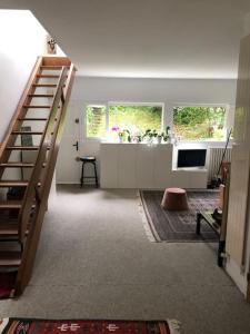 uma sala de estar com uma escada e uma televisão em Maison familiale et lumineuse avec jardin em Versalhes