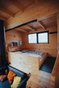 een kleine kamer met een bed in een houten hut bij Tiny Dream House 4p in Arnhem