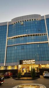 a large glass building with cars parked in a parking lot at EWG Al Hamra Hotel in Jeddah