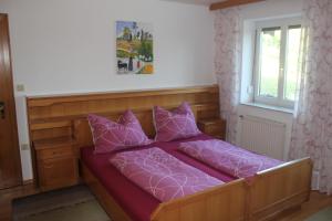 een bed met paarse lakens en kussens in een kamer bij Hof Sonnegg - Naturpark Jauerling - Wachau in Maria Laach am Jauerling