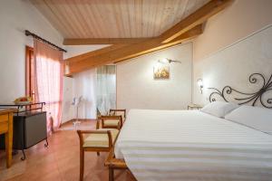 a bedroom with a large white bed and a desk at Lola Piccolo Hotel e Appartamenti in Marina di Grosseto