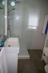 uma casa de banho branca com um chuveiro e um lavatório. em Garrucha's Beach Aldea Marina em Vera