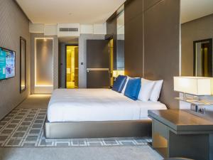 um quarto de hotel com uma cama e uma televisão em HomesGetaway-Lavish1BR in Hyatt Regency Creek Heights Residences em Dubai