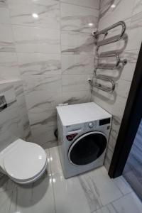 a bathroom with a toilet and a microwave at Apartamentai in Marijampolė