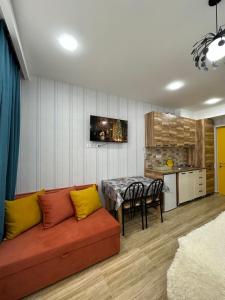 uma sala de estar com um sofá vermelho e uma mesa em Bakuriani Mix 213 em Bakuriani