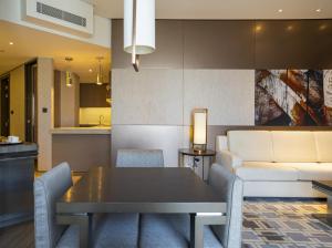 uma sala de estar com uma mesa e um sofá em HomesGetaway-Lavish1BR in Hyatt Regency Creek Heights Residences em Dubai