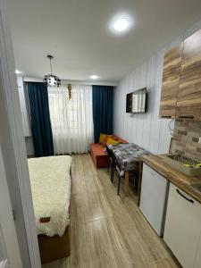 uma cozinha e sala de estar com uma mesa e um sofá em Bakuriani Mix 213 em Bakuriani
