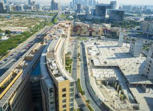 an aerial view of a city with buildings and a train at HomesGetaway-Lavish1BR in Hyatt Regency Creek Heights Residences in Dubai