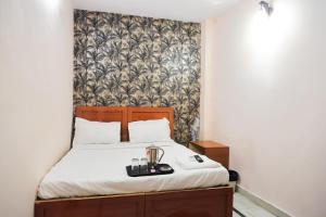 1 dormitorio con 1 cama con sábanas blancas y papel pintado en Hotel In laxmi nagar - Mannat Stay, en Nueva Delhi