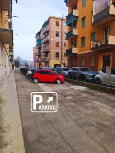 a red car is parked in a parking lot at Pasubio Apartment in Bologna