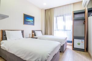 ein Hotelzimmer mit 2 Betten und einem Fenster in der Unterkunft Campus Butik Hotel in Avcılar