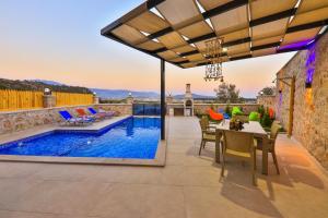 un patio con piscina, mesa y sillas en Villa Sandak 1 en Bulmaç