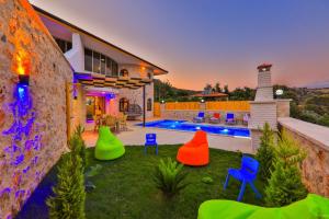 podwórko z kolorowymi krzesłami i basen w obiekcie Villa Sandak 1 w mieście Bulmaç