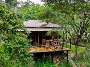 a restaurant on a deck in the forest at Oasis forest garden in Ban Takuk Nua