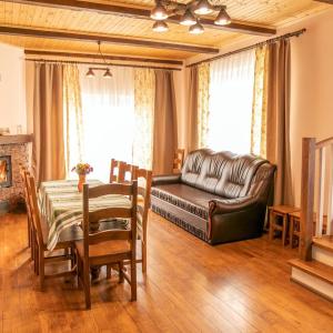 a living room with a leather couch and a table at Мигово Гражда in Migovo