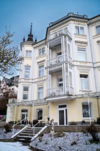 a large white building with stairs in front of it at Trip Inn Parkhotel Bad Ems in Bad Ems
