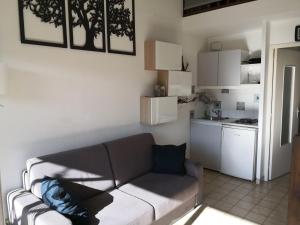 a living room with a couch and a kitchen at Duplex Hyères Port in Hyères