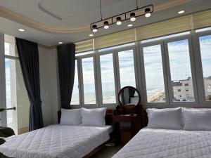 two beds in a room with large windows at Khách Sạn A68 in Chợ Phước Hải +48 photos