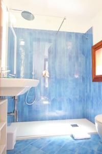 y baño de azulejos azules con ducha y lavamanos. en Casa Teresina Minori Apartment, en Minori