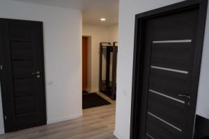 a room with two black doors and a hallway at Apartamentai in Marijampolė