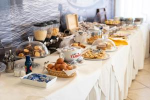 a buffet of food on a long table at Lola Piccolo Hotel e Appartamenti in Marina di Grosseto