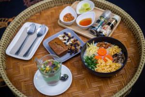 a table with a bowl of food and a plate of food at Oasis forest garden in Ban Takuk Nua