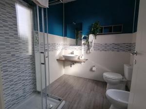 uma casa de banho com um WC, um lavatório e um chuveiro em Dimora Bed and Breakfast em San Gavino Monreale