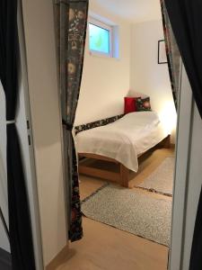 um pequeno quarto com uma cama e uma janela em Haus LUNA - Privatzimmer im sonnigen Südburgenland em Hackerberg