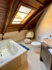 uma casa de banho com uma banheira, um WC e uma clarabóia em El Patio de Toledo em Toledo
