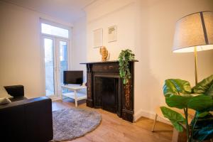 a living room with a fireplace and a lamp at Dallow Rd Serviced Accommodation in Luton