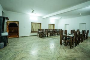 a dining room with wooden tables and chairs at Sandcastle Resort in Jaisalmer