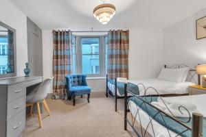 - une chambre avec deux lits, un bureau et une chaise dans l'établissement Seaside Sanctuary House By My Getaways, à Brighton et Hove