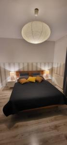 a bedroom with a large black bed with two lamps at Apartament Czerwone Maki in Krakow