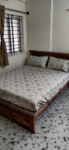 a large bed in a room with a window at Castle Hebbal Service Apartments in Bangalore