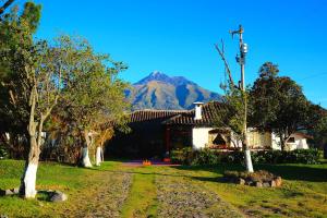 a house with a mountain in the background at B&B Cotacachi Hosteria Oro Azul in Cotacachi
