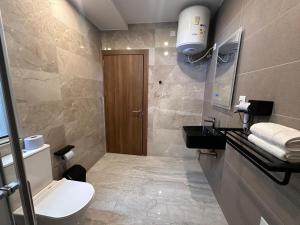 a bathroom with a toilet and a sink at La Bella Guesthouse in St. Julianʼs