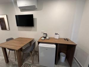 a room with a desk and a table and a small table and a television at La Bella Guesthouse in St. Julianʼs