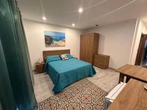 a bedroom with a bed with a green comforter at La Bella Guesthouse in St. Julianʼs