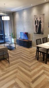 a living room with a table and a tv on the wall at Active Residence C 408 in Lublin