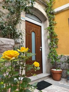 una puerta a un edificio con flores amarillas delante en Casanica-Taormina, en Taormina