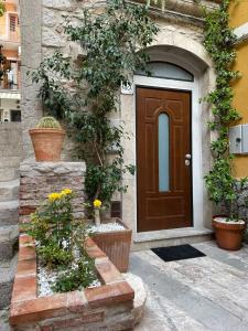 Una porta di una casa con dei fiori davanti di Casanica-Taormina a Taormina