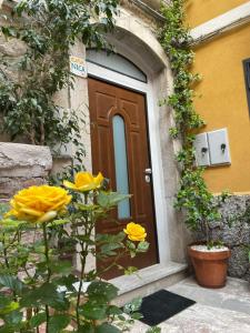 una puerta a un edificio con flores amarillas delante en Casanica-Taormina en Taormina