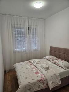a bedroom with a bed and a window at Apartment Dora in Banja Luka